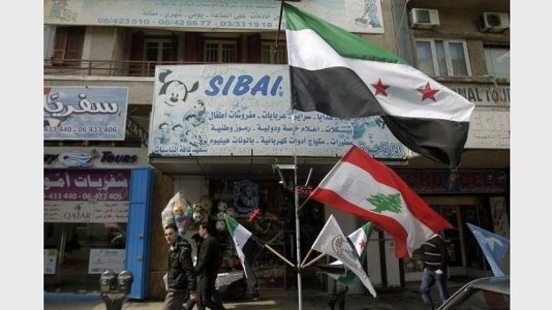 Un drapeau de la rébellion syrienne et un drapeau libanais devant une boutique dans une rue de Tripoli, au Liban, le 2 mars 2012 