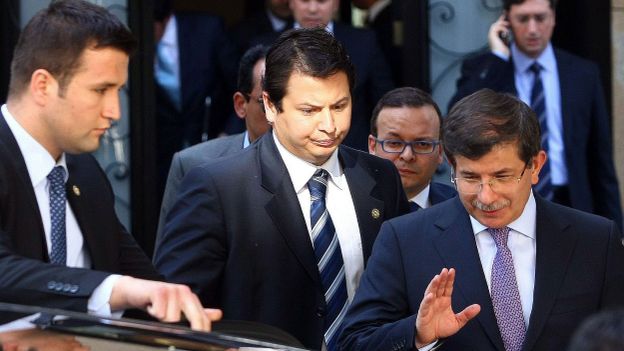 Le ministre turc des Affaires étrangères Ahmet Davutoglu (D) quitte une réunion à propos de la Syrie en compagnie de militaires syriens