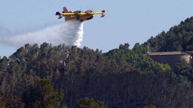 Un canadair déverse sa cargaison d'eau sur l'incendie