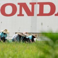 Les jardiniers entretiennent les plantations près de l'usine Honda dans la province de Guangdong