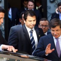 Le ministre turc des Affaires étrangères Ahmet Davutoglu (D) quitte une réunion à propos de la Syrie en compagnie de militaires syriens